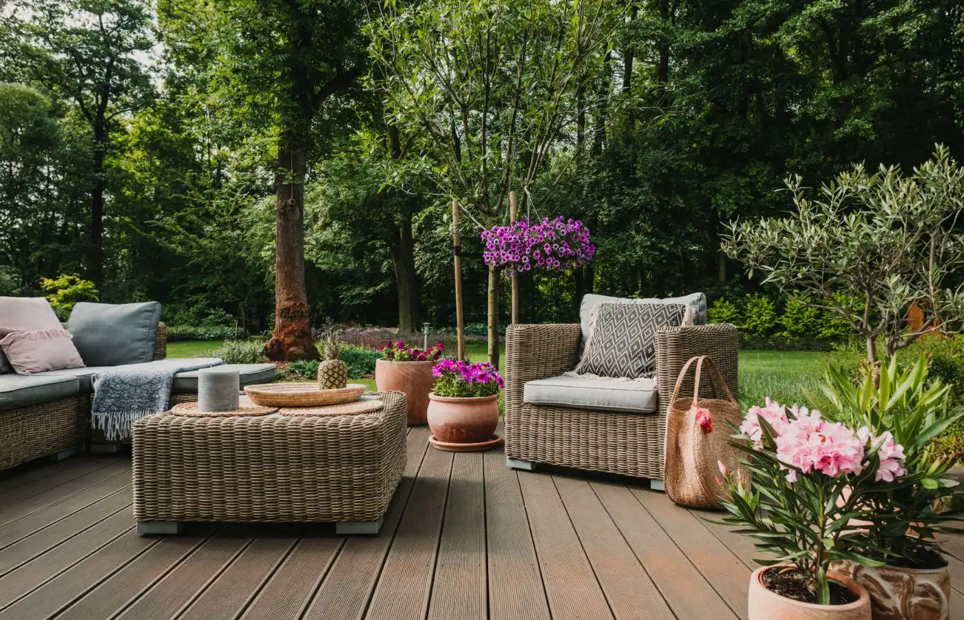 jardinetdeco-coin_amenagement Coin de jardin aménagé avec des fauteuils en rotin, des plantes en pot et une décoration harmonieuse pour une atmosphère relaxante et naturelle.